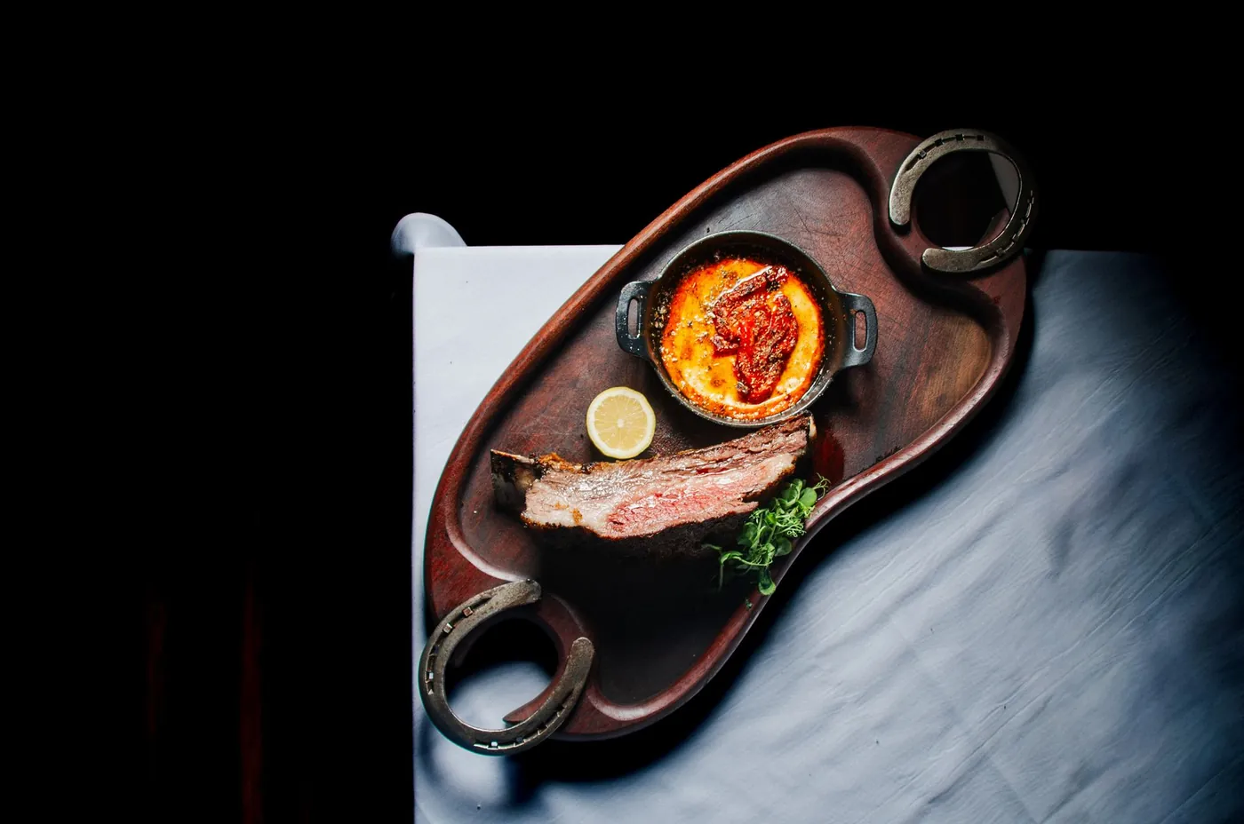 Provoleta melted in a cast-iron dish next to a steak